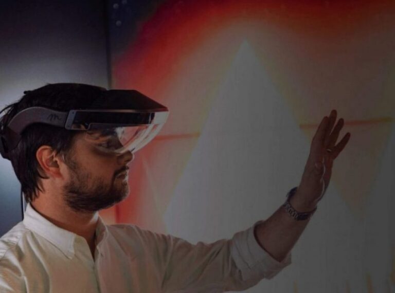 a man wearing a headset with his left hand in the air