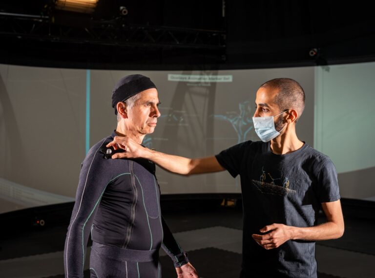 Two people working on motion capture at the CAMEA studio.
