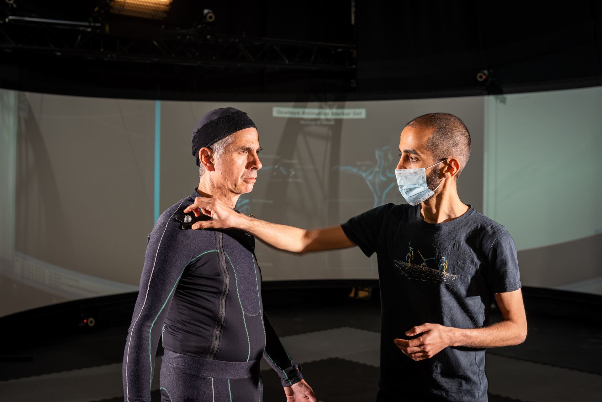 Two people working on motion capture at the CAMEA studio.