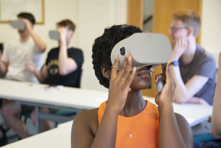 A woman wearing a VR headset wearing an orange vest looking upwards