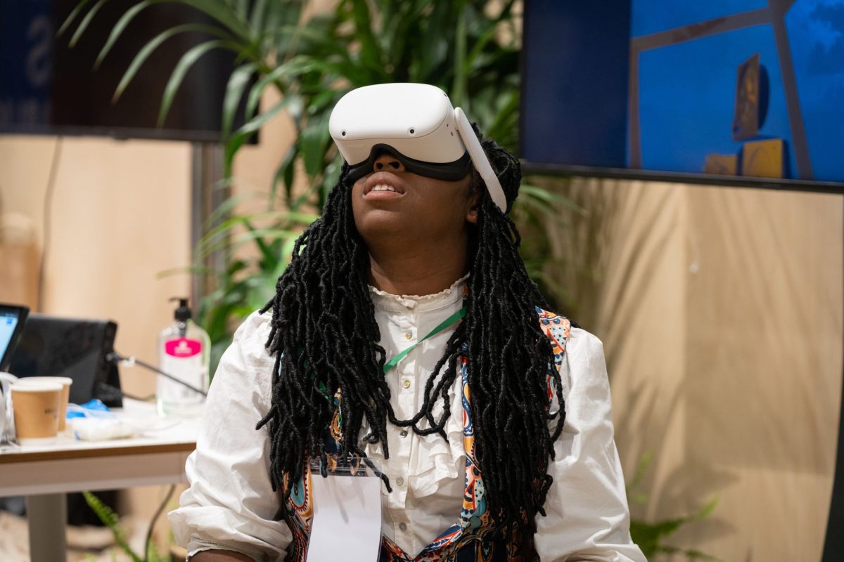 A woman sat wearing a VR headset, looking up