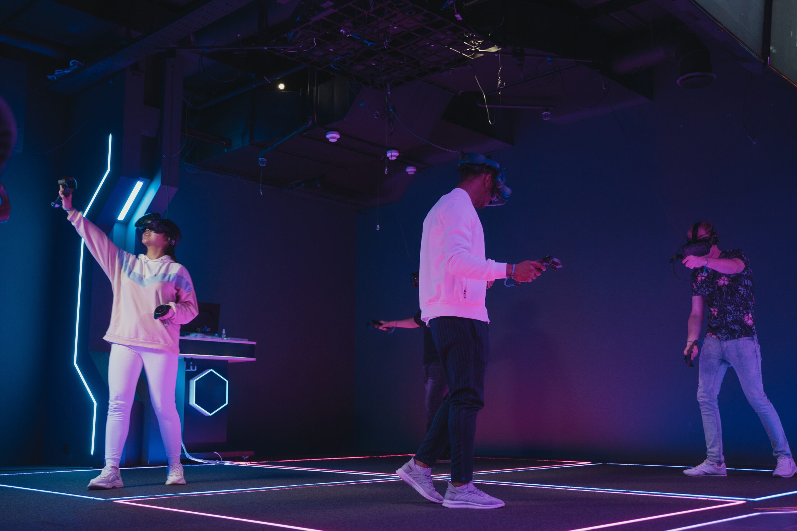 A group of people wearing VR headsets in a studio lit by blue and purple lights