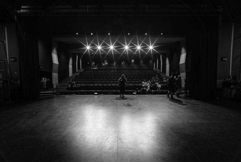 grayscale photo of people on stage