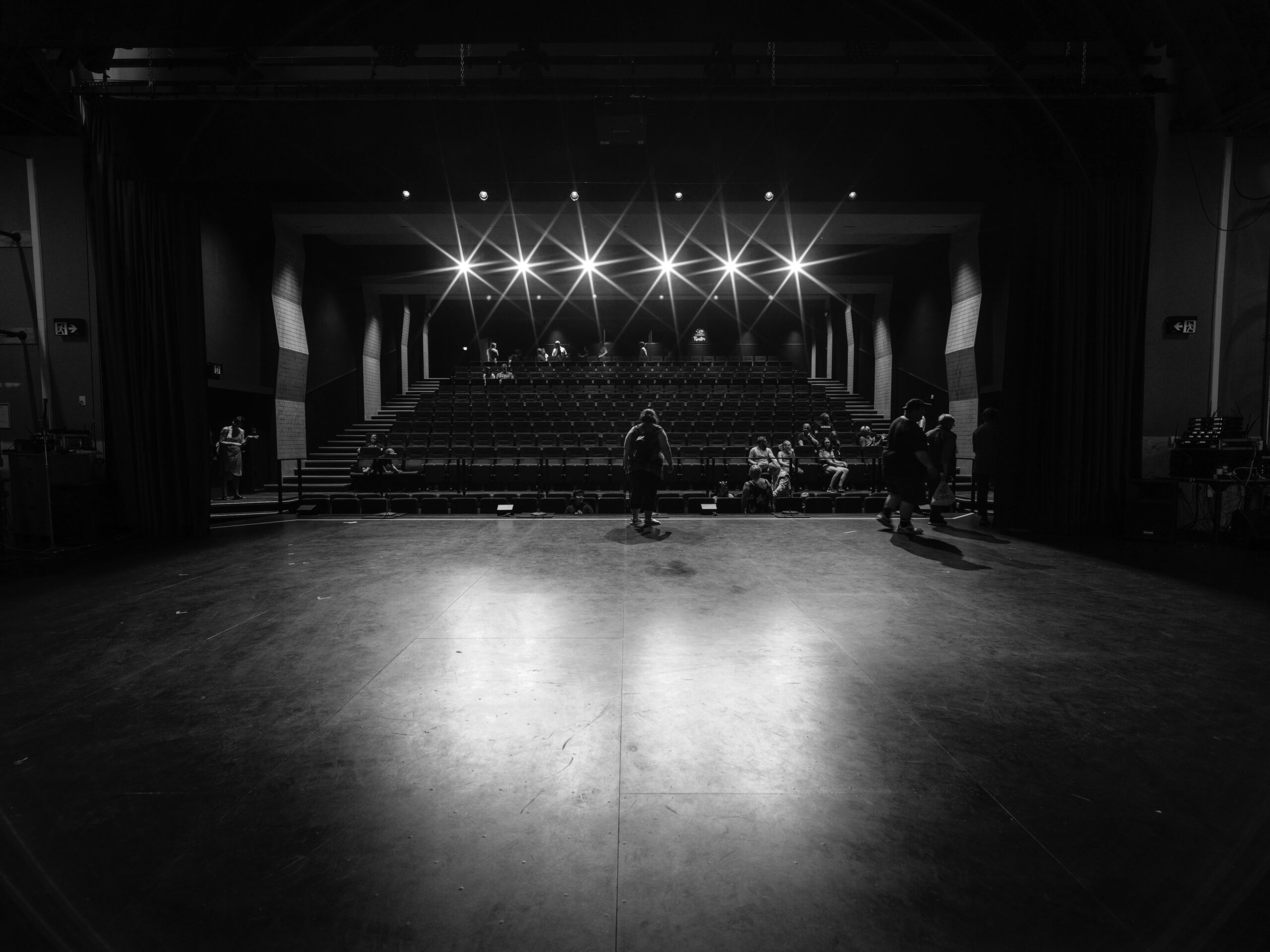 grayscale photo of people on stage