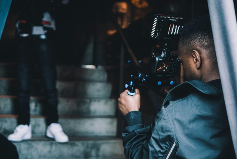 man with a camera recording video on stairs